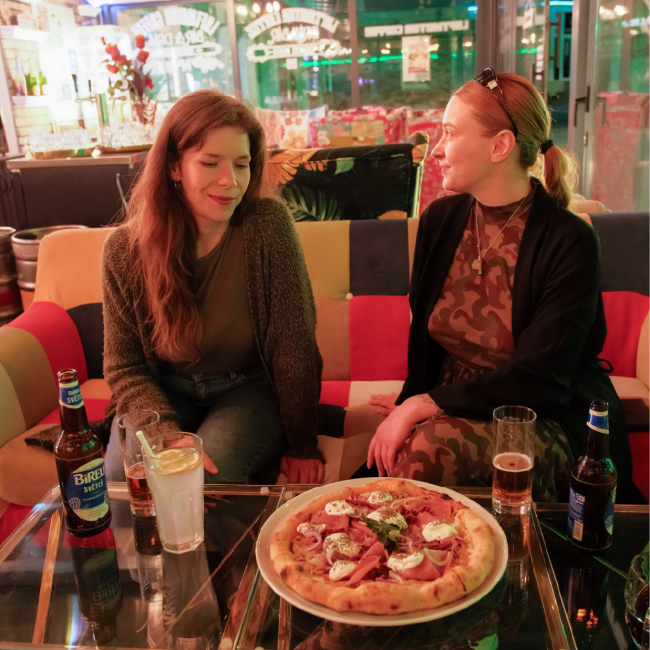 Don Corleone Pizza - dve ženy s pizzou v interiéry - fotografia